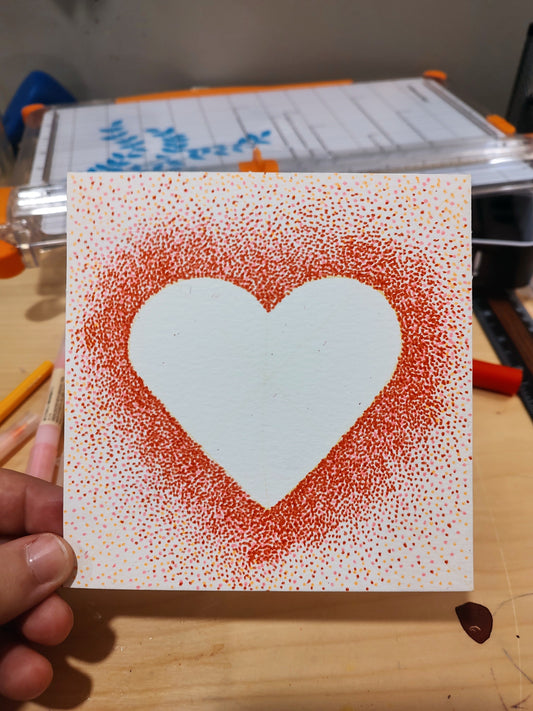 A pointillism heart made of red dots. 
